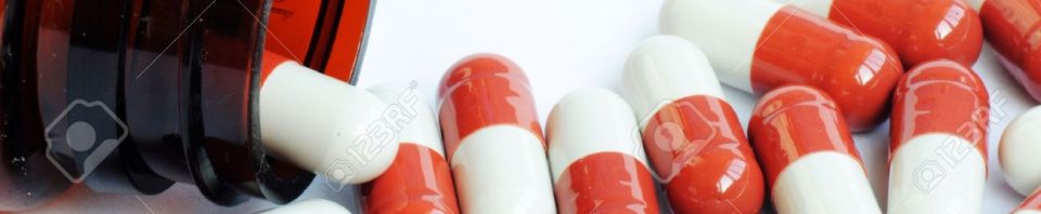 13763178-Red-and-white-medicine-capsules-from-a-bottle-Stock-Photo